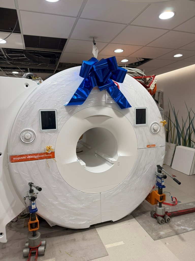 PET/MR scanner wrapped in plastic and topped with a big blue bow.