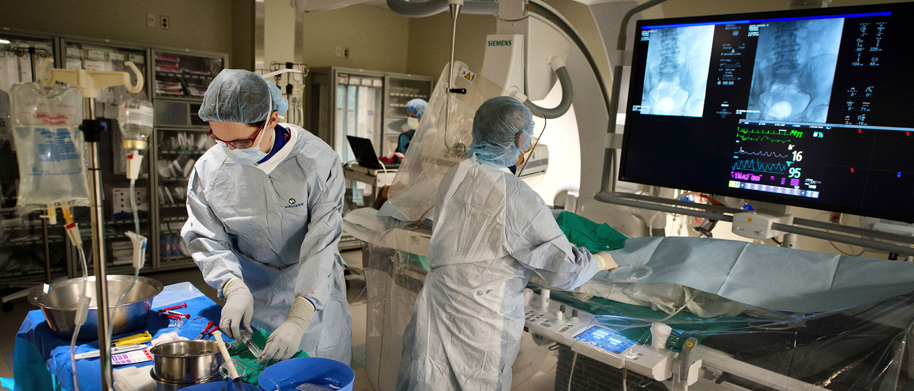 Two interventional radiologists prepping a patient for procedure