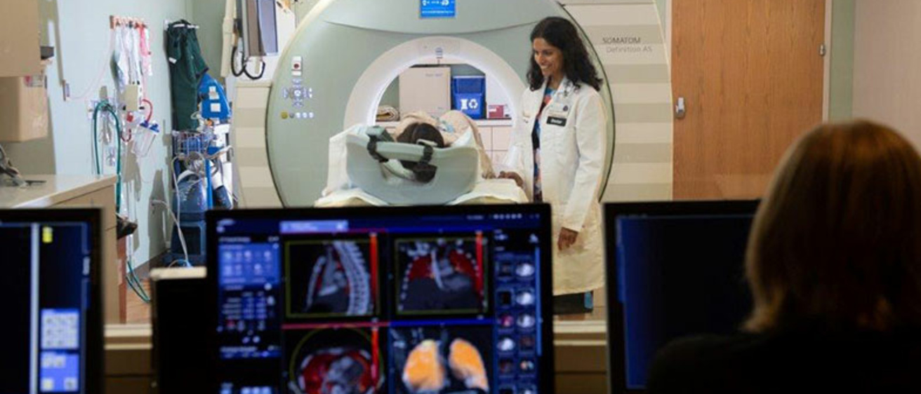Radiologist speaking to patient laying on an MRI scanner