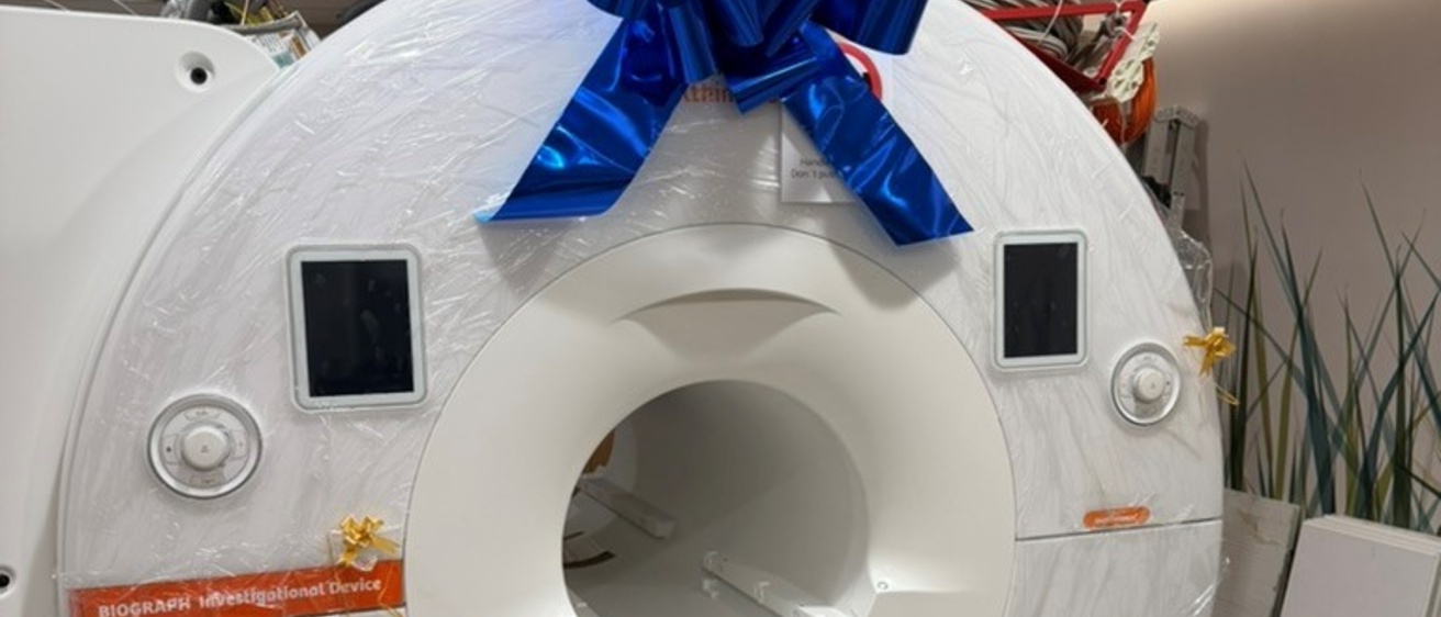 PET/MR scanner wrapped in plastic and topped with a big blue bow.