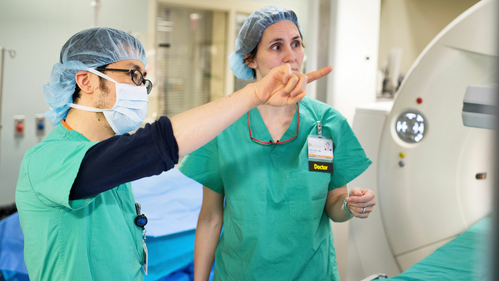 Two radiologists consulting about a patient case in the interventional suite