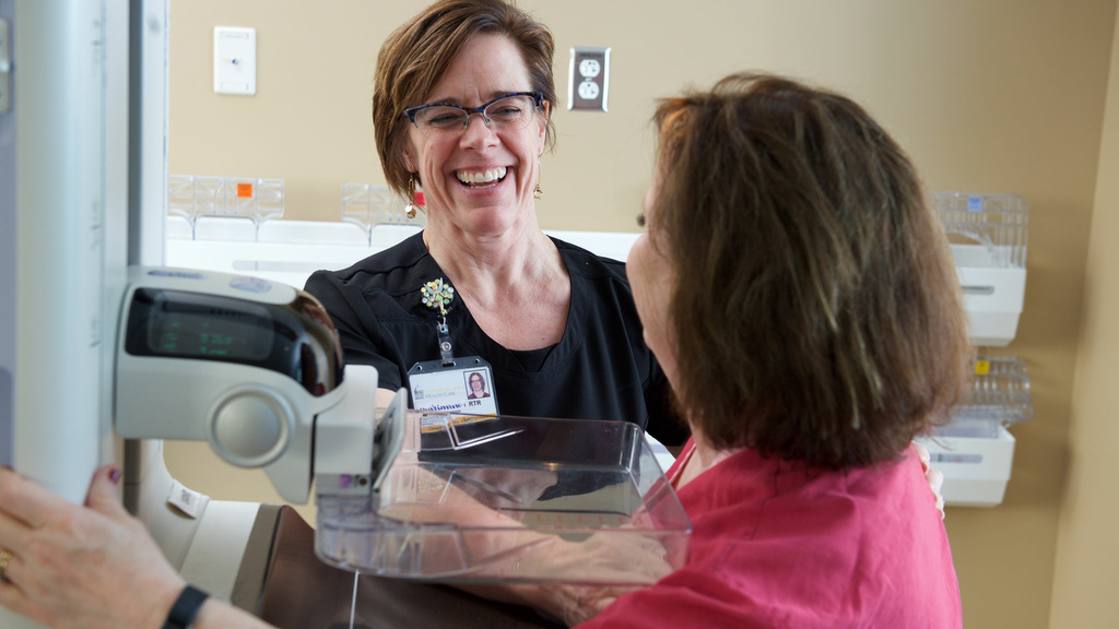Technologist speaking to patient undergoing a mammography