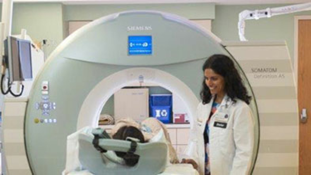 Radiologist speaking to patient lying on an MRI scanner