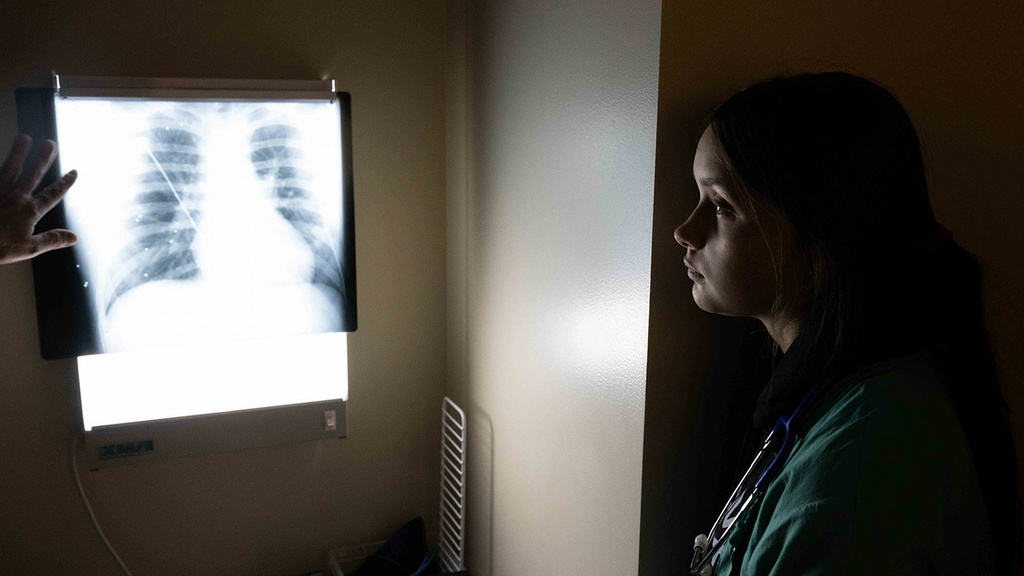 Technologist looks at a chest x-ray in a dark room