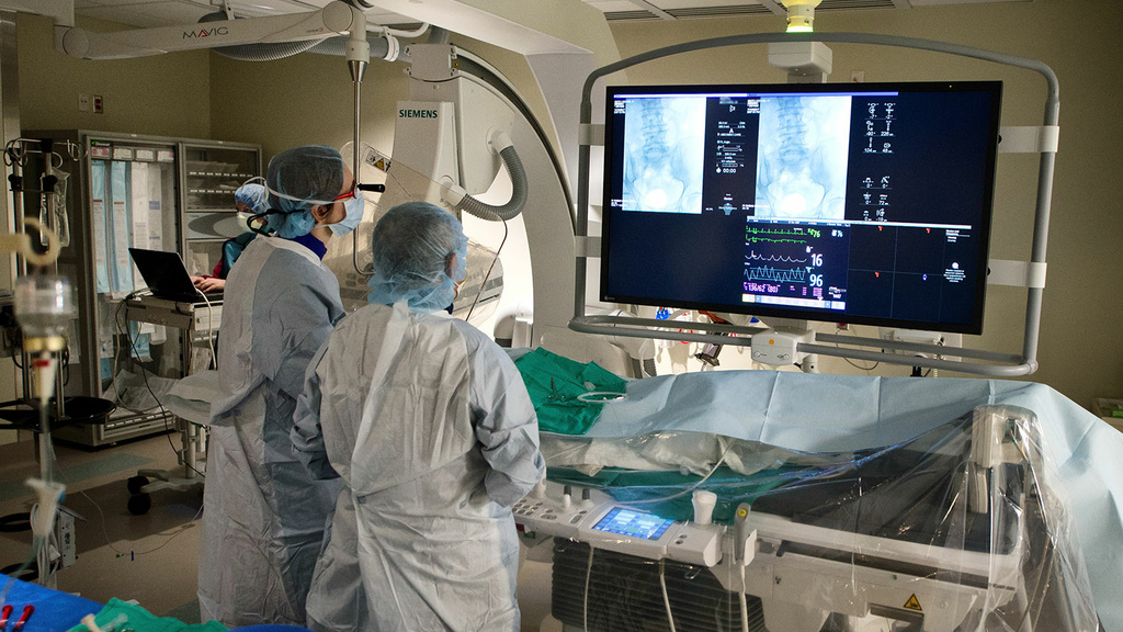 Two radiologists performing an interventional procedure on a patient
