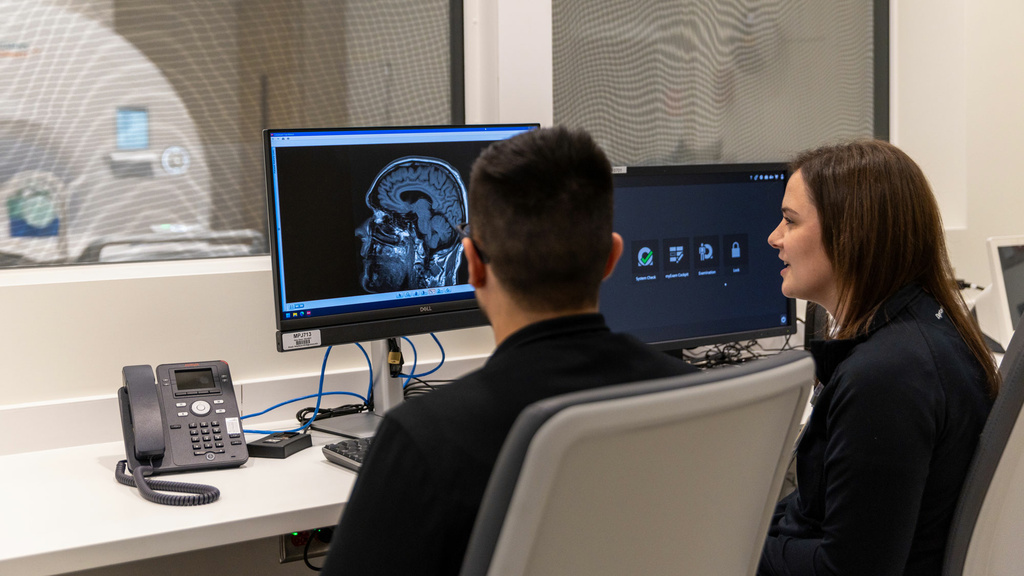 Two rad techs looking at a brain MRI scan