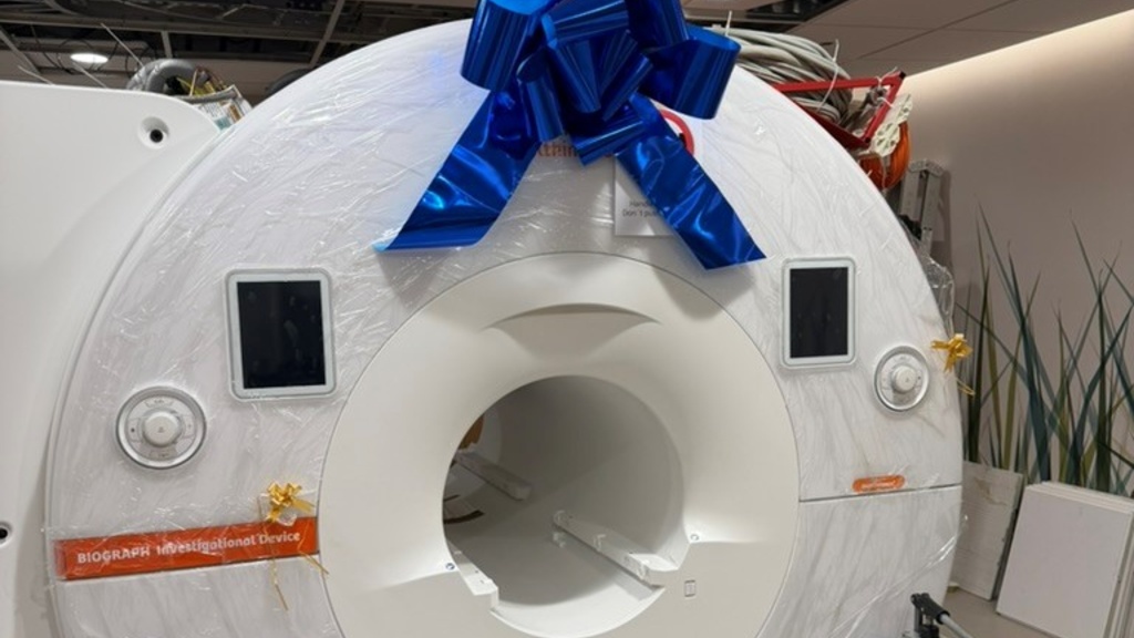PET/MR scanner wrapped in plastic and topped with a big blue bow.