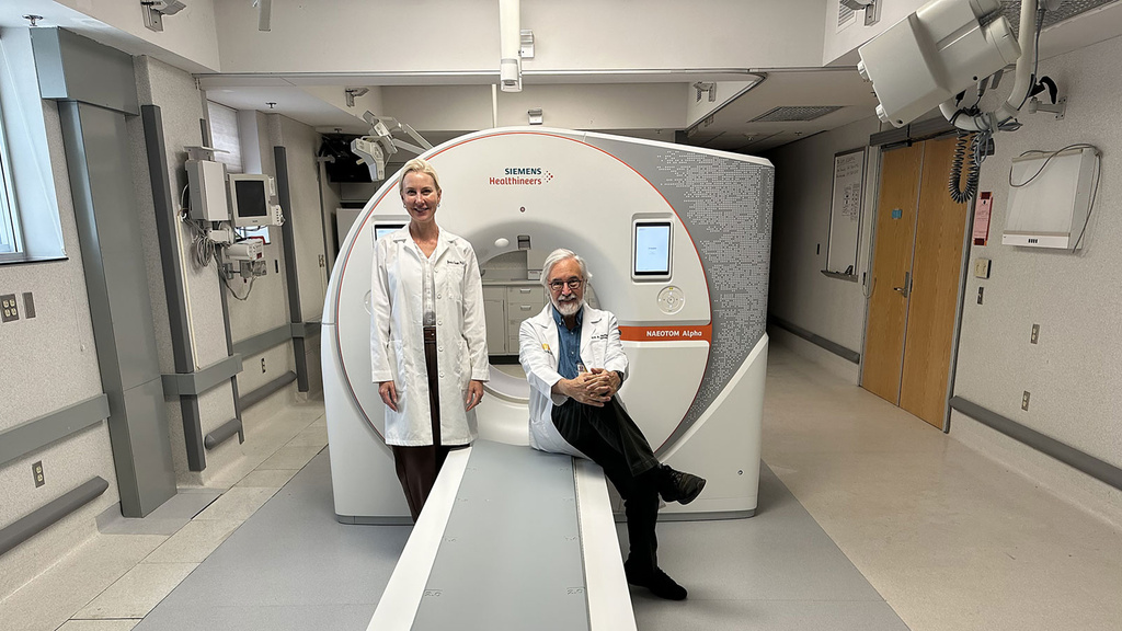 Drs. Eric Hoffman and Jessica Sieren pose next to scanner